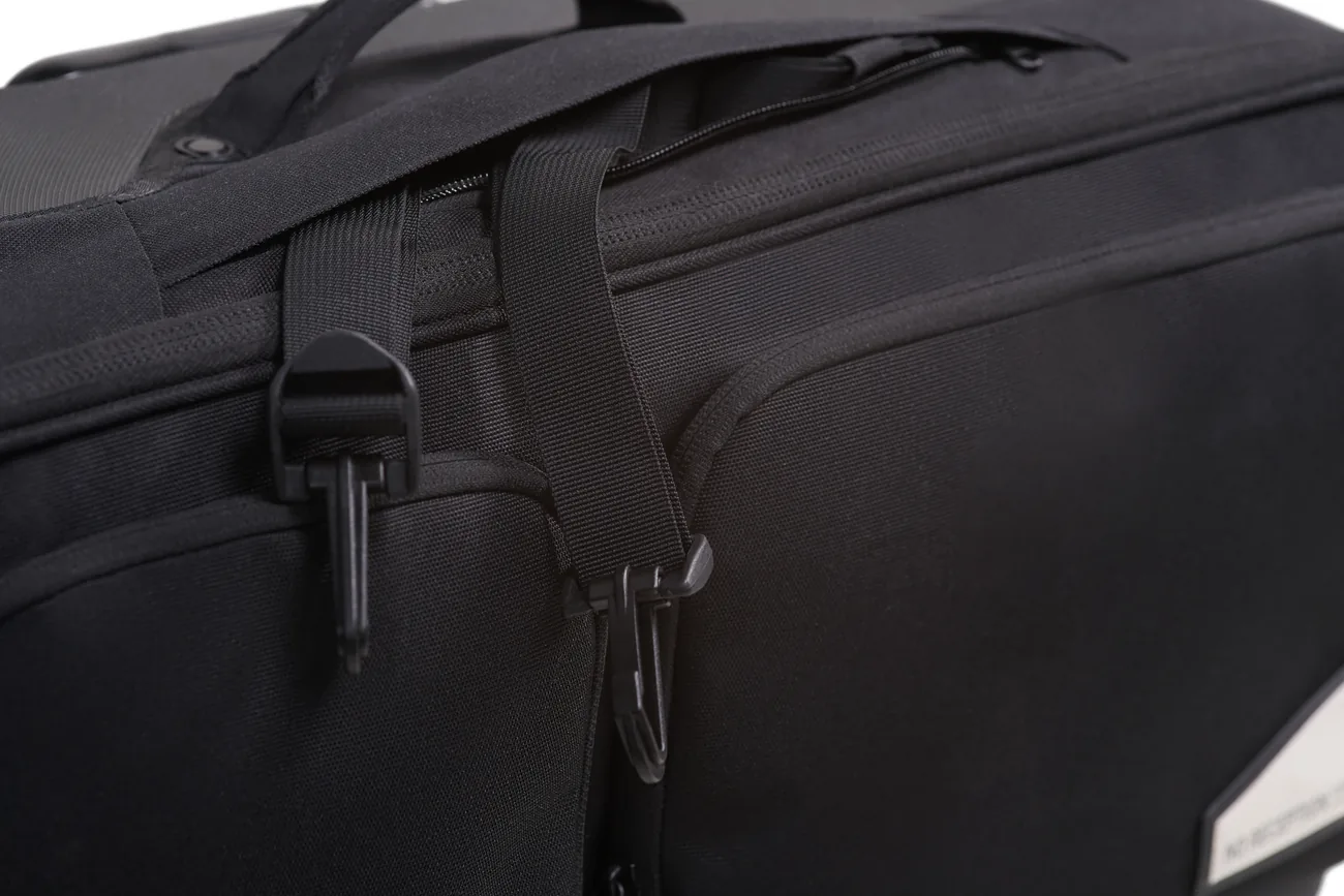 Close-up of a strap and buckle detail on the black Rollaway suitcase