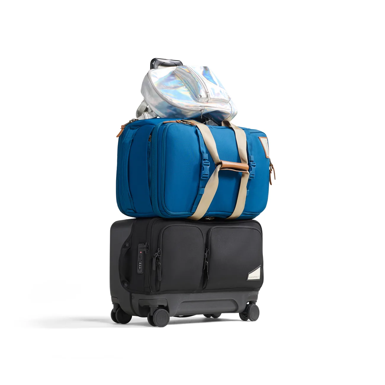 Blue bag and other travel items stacked above a Rollaway suitcase